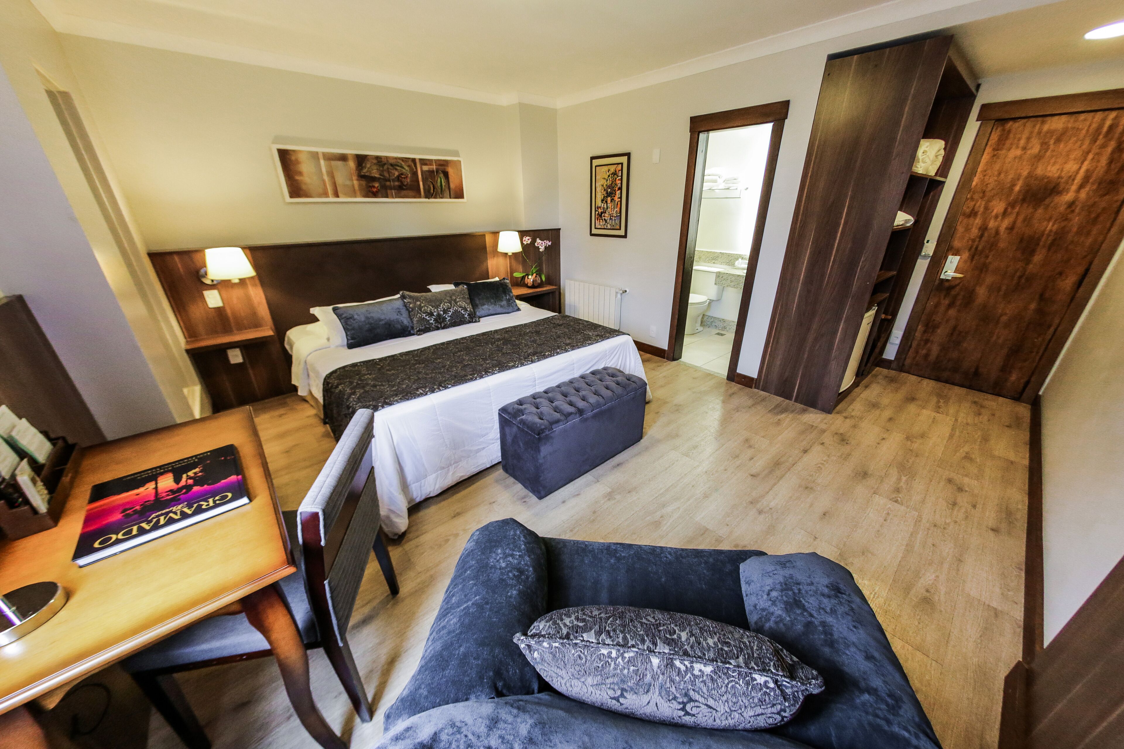 Une chambre d’hôtel avec un lit, un bureau, une chaise et un canapé.