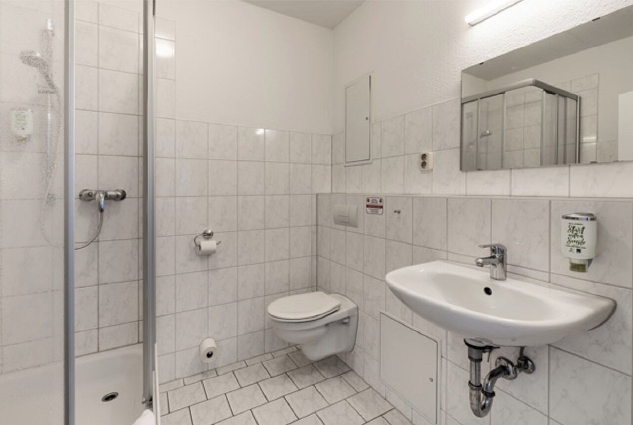 Ein Badezimmer mit Dusche, Toilette und Waschbecken.