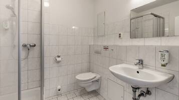 Un bagno con doccia, WC e lavandino.