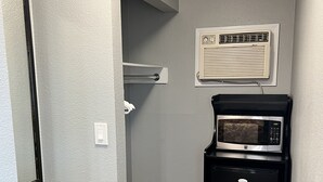 Eine kompakte Küchenzeile mit Mikrowelle, Kühlschrank und einer kleinen Arbeitsfläche.