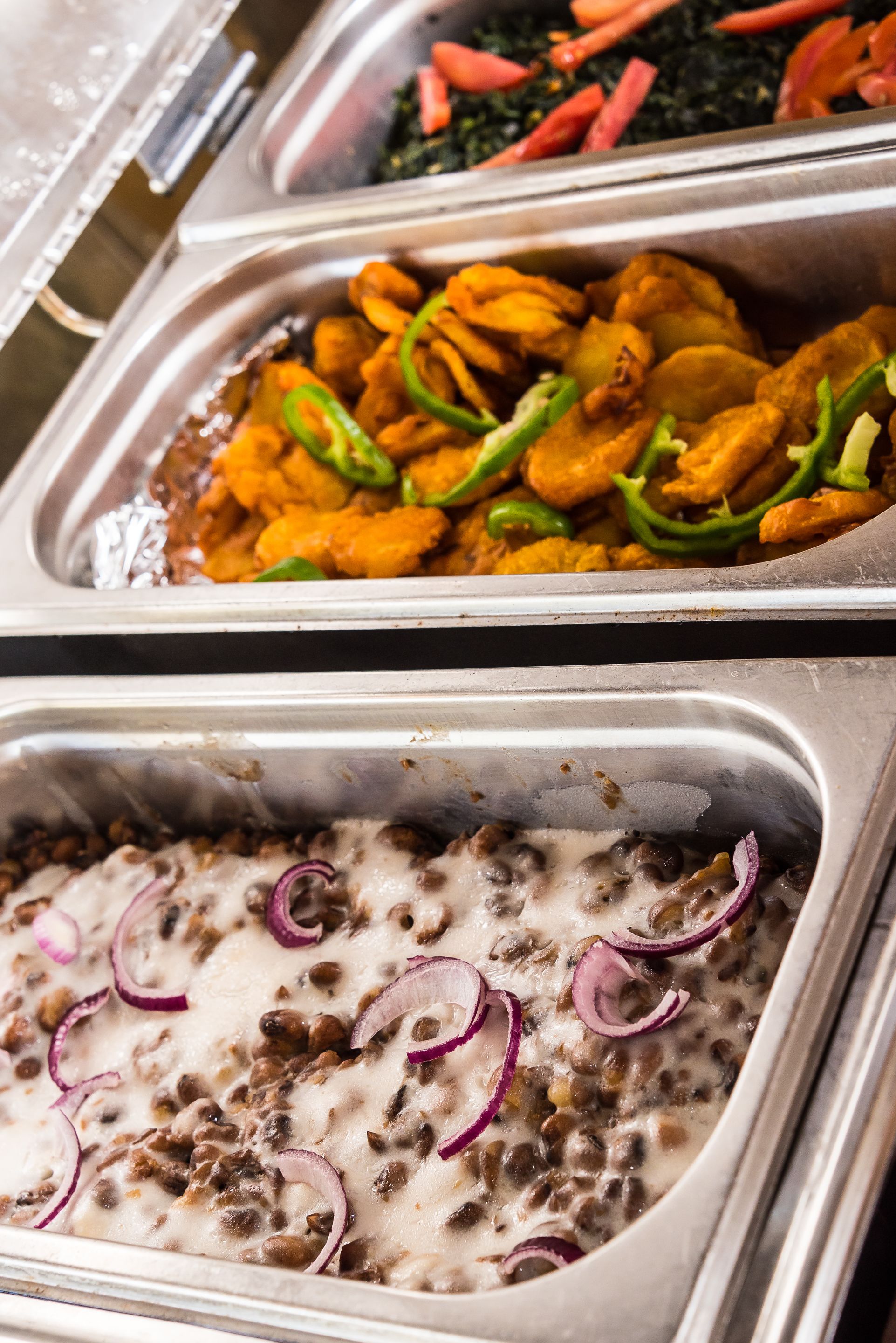 A buffet with various dishes including fried items and a creamy lentil dish.
