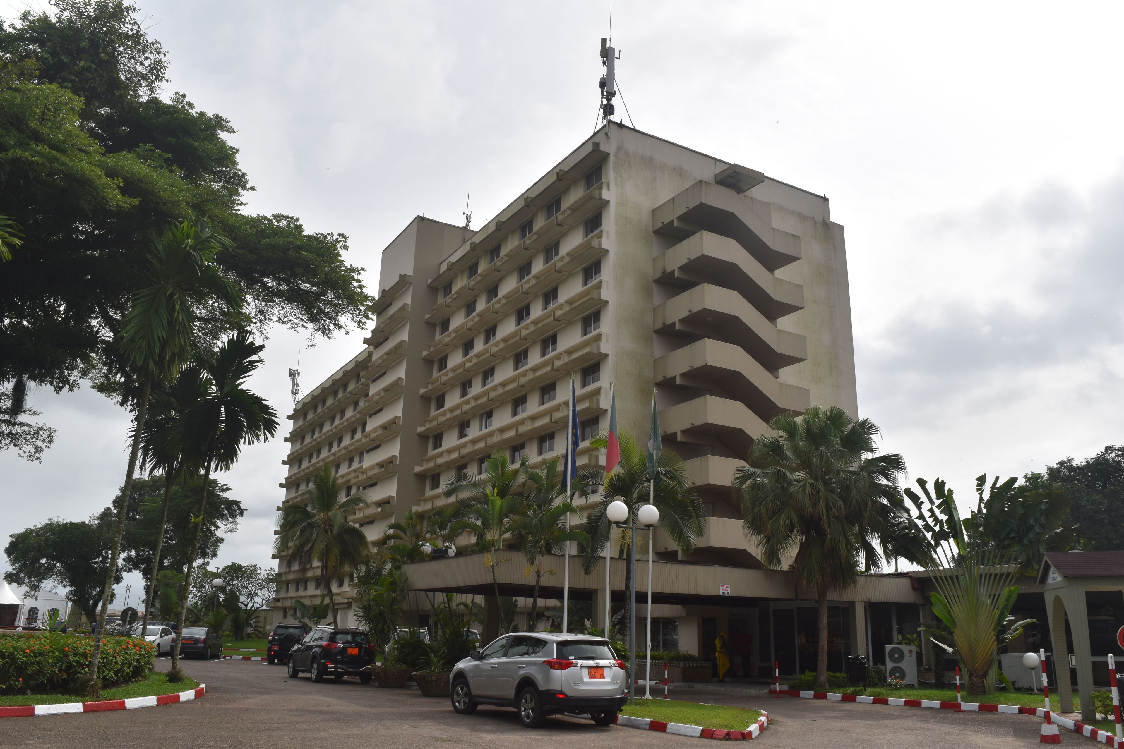 Un hôtel à plusieurs étages doté d’une architecture moderne, avec des balcons et une entrée principale.