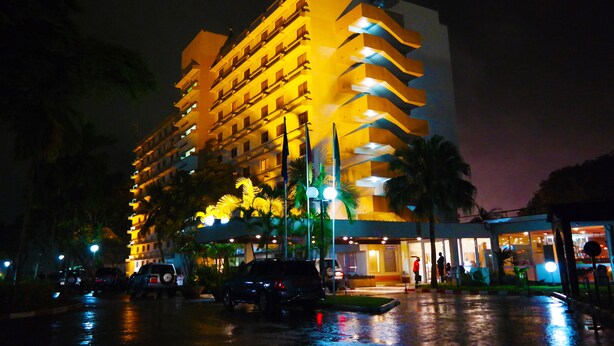 A multi-story hotel with a modern design, featuring balconies and a well-lit entrance. - Hôtel SAWA (Douala)