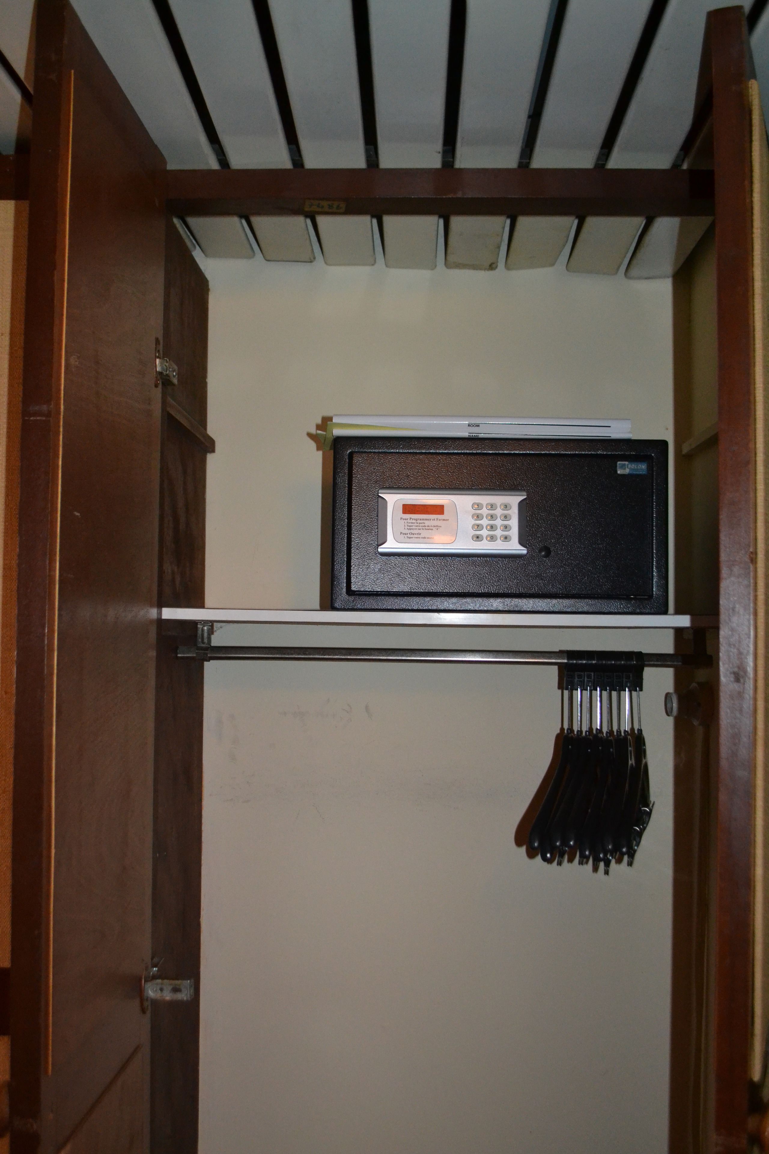 A compact room with a built-in microwave on a shelf, a small cabinet, and a hanging rack with keys.