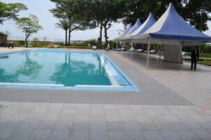 Una piscina al aire libre, sombrillas