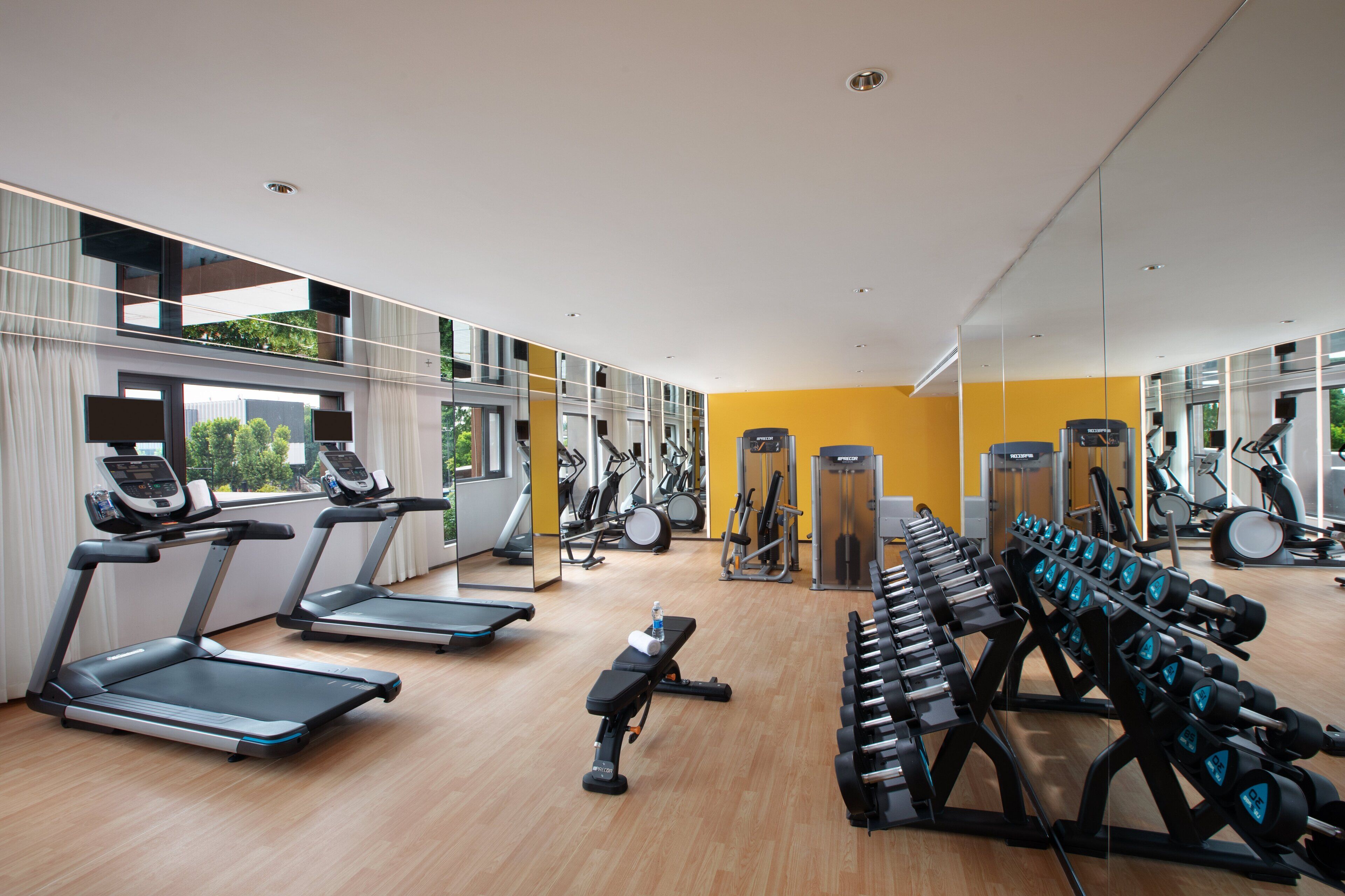 Un gimnasio moderno con cintas de correr, mancuernas y equipo de ejercicio.