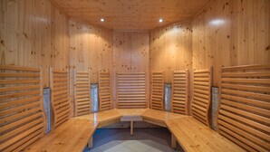 A sauna room with wooden benches and slatted walls. - JUFA Hotel Altaussee (Altaussee)