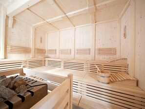 Un onsen japonés tradicional con bancos de madera y una pila de piedra.