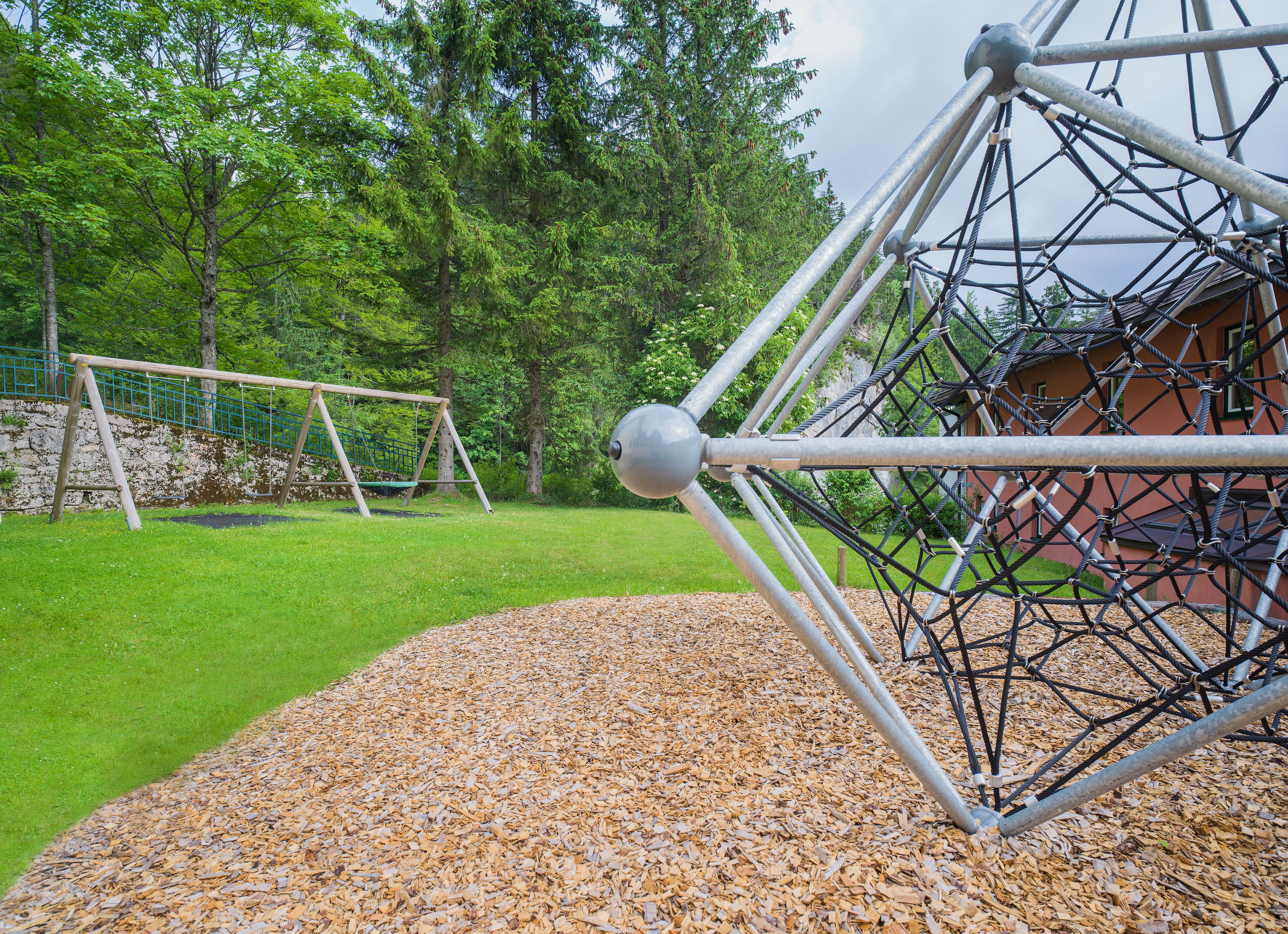 A playground with a swing set and a climbing structure.