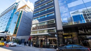 Un hotel moderno con fachada de vidrio, varios pisos y un llamativo letrero 'myhotel'.