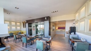 Un moderno vestíbulo de hotel con comedor, mostrador de recepción y vistas a la ciudad.
