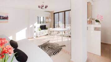 Ein modernes Wohnzimmer mit einer Couch, einem zebra-gemusterten Teppich und einem Essbereich mit Tisch und Stühlen.