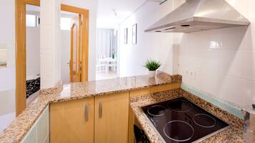 A modern kitchen with granite countertops, a stainless steel range hood, and a built-in stovetop.
