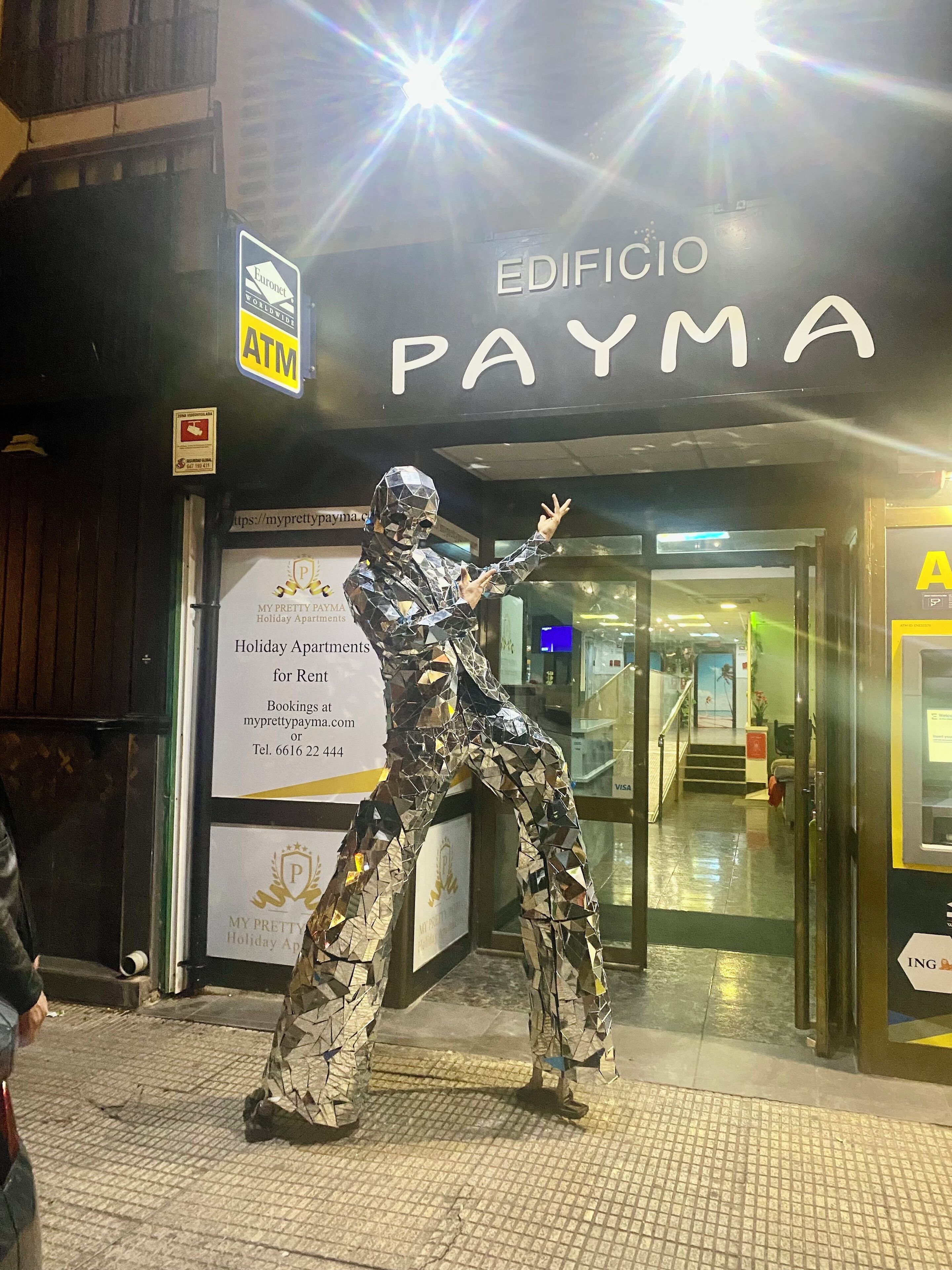 A building entrance with a sign for 'EDIFICIO PAYMA' and an ATM.