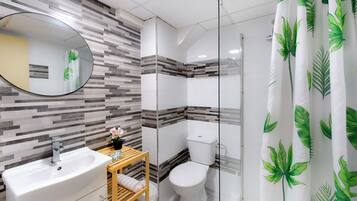 A bathroom with a modern design, featuring a sink, toilet, and shower area.