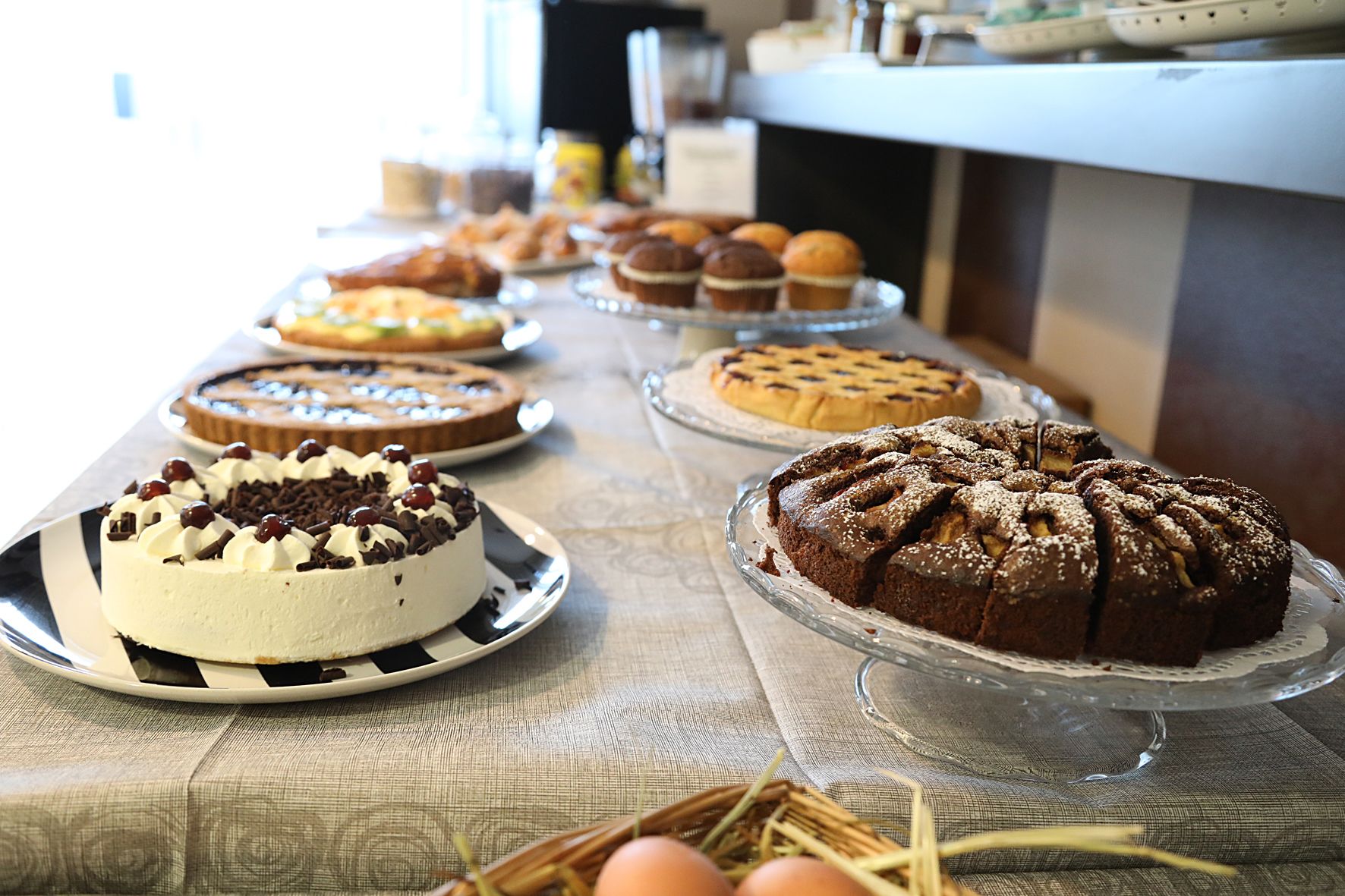A buffet table with various cakes and pastries.