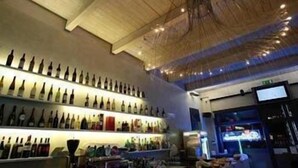 A bar with shelves of bottles and a ceiling with a unique design. - Fidenza Hotel (Fidenza)