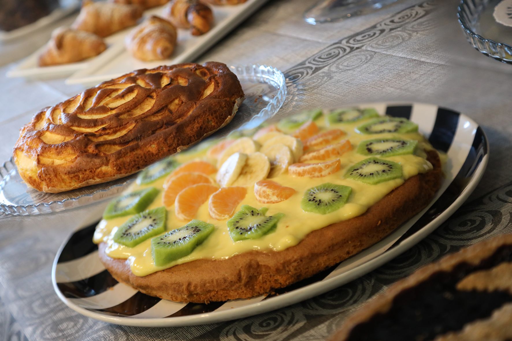 Un tavolo con un piatto di pasticcini e un cornetto.
