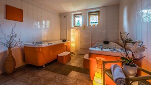 A bathroom with two tubs, a sink, a mirror, and a window.