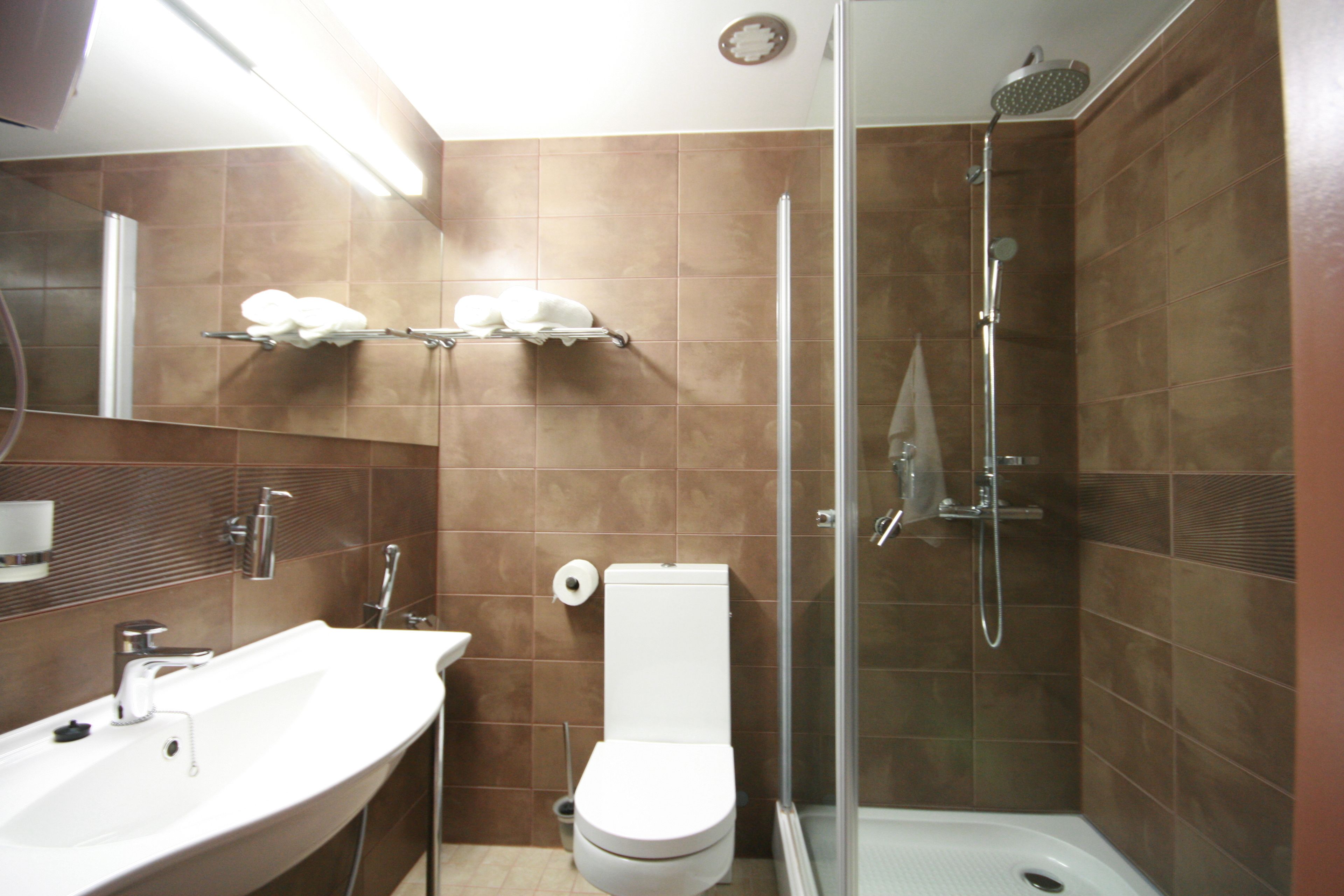 A modern bathroom with a sink, toilet, and glass-enclosed shower.