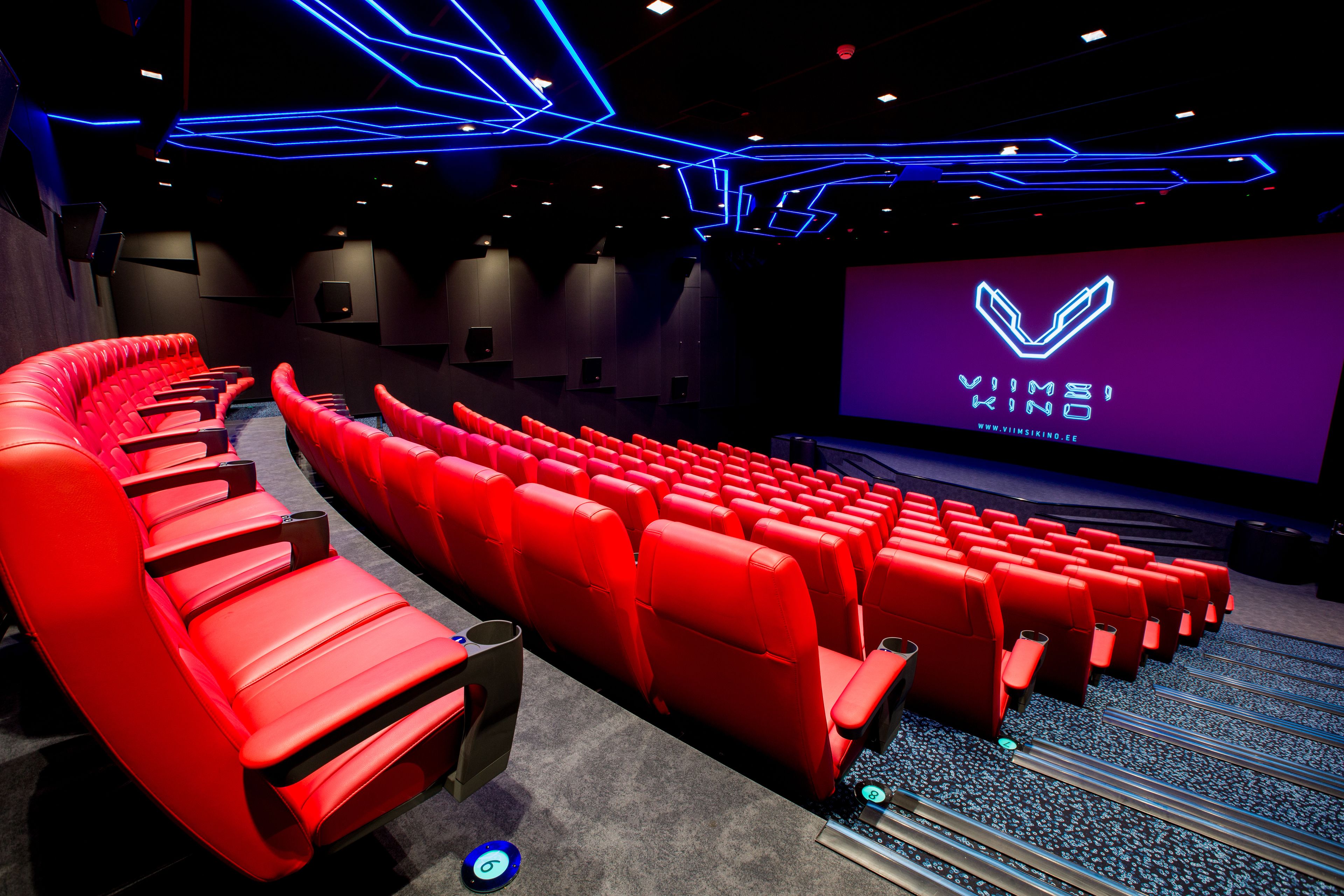 A cinema with red seats and a large screen displaying the VIMSI KINO logo.