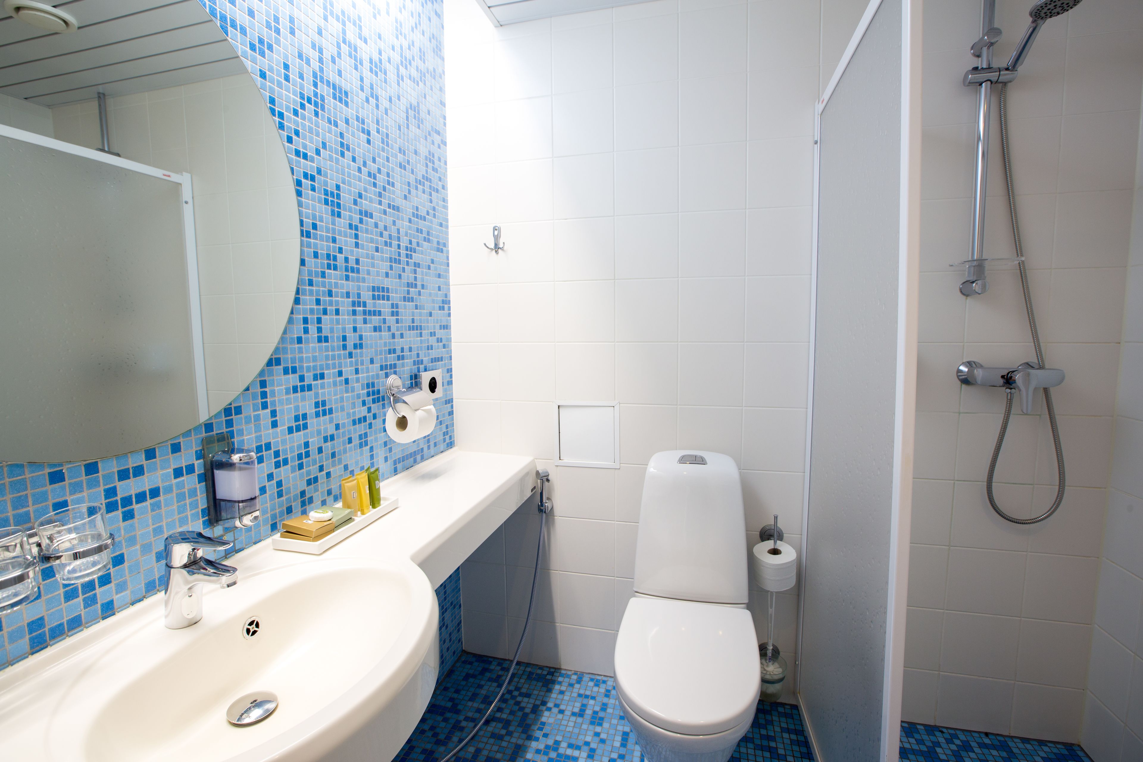 A bathroom with a sink, toilet, and shower.