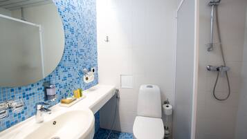 A bathroom with a sink, toilet, and shower.