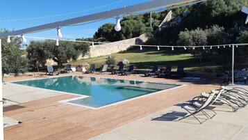 Una piscina al aire libre, tumbonas
