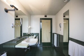 A modern bathroom with a large mirror, a sink, and a shower.