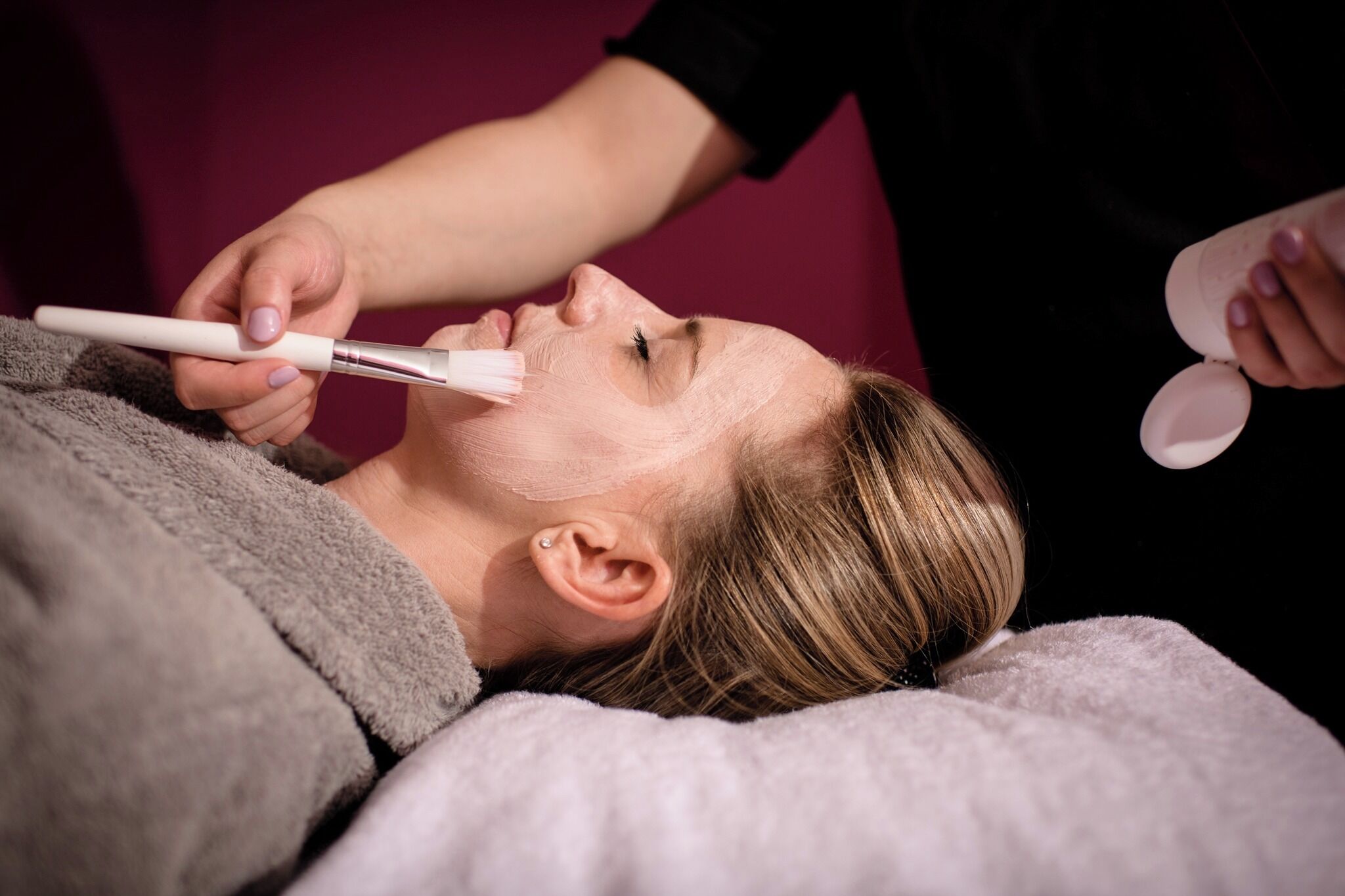 Uma pessoa deitada enquanto uma máscara facial é aplicada.