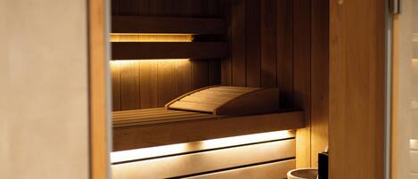Una sauna con bancos de madera y calentador.