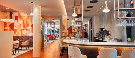 A modern bar area with a curved counter, bar stools, and a bartender.