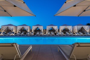 Una piscina al aire libre, cabañas de piscina (de pago)