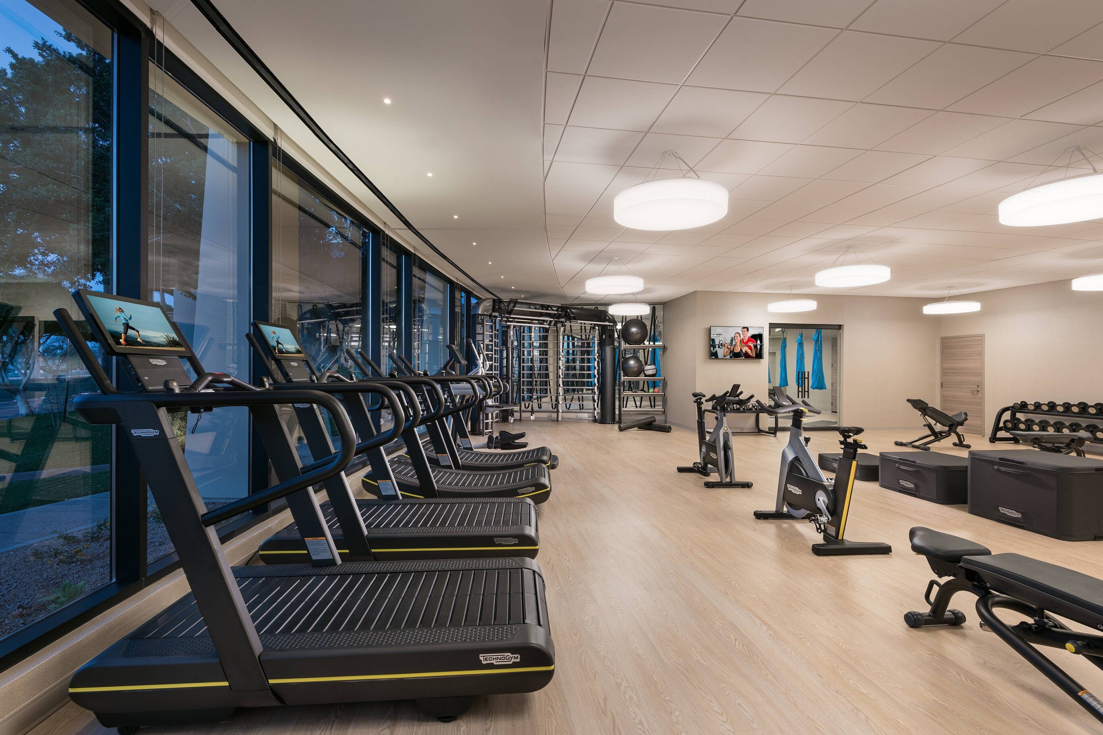 A gym with treadmills, exercise bikes, and weight machines.