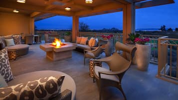 Un espace extérieur aménagé avec une terrasse, un foyer et une vue sur le paysage.
