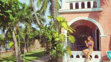 Guests can unwind in a serene garden setting surrounded by tropical plants and palm trees.