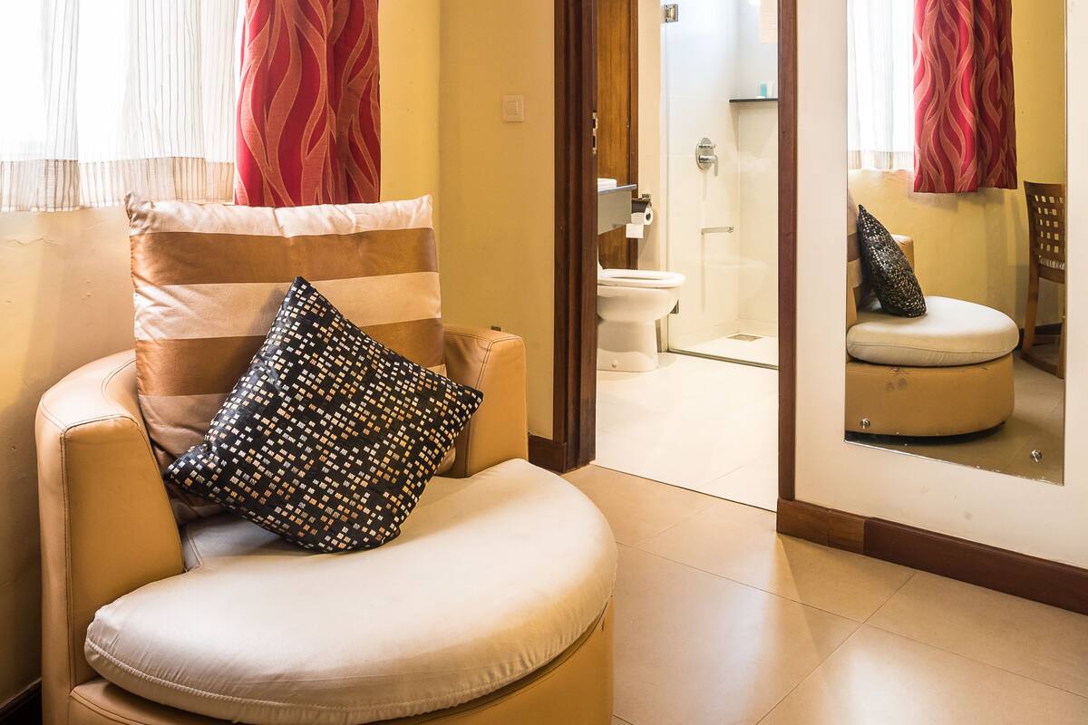 A modern bathroom with a shower, toilet, and a mirror.