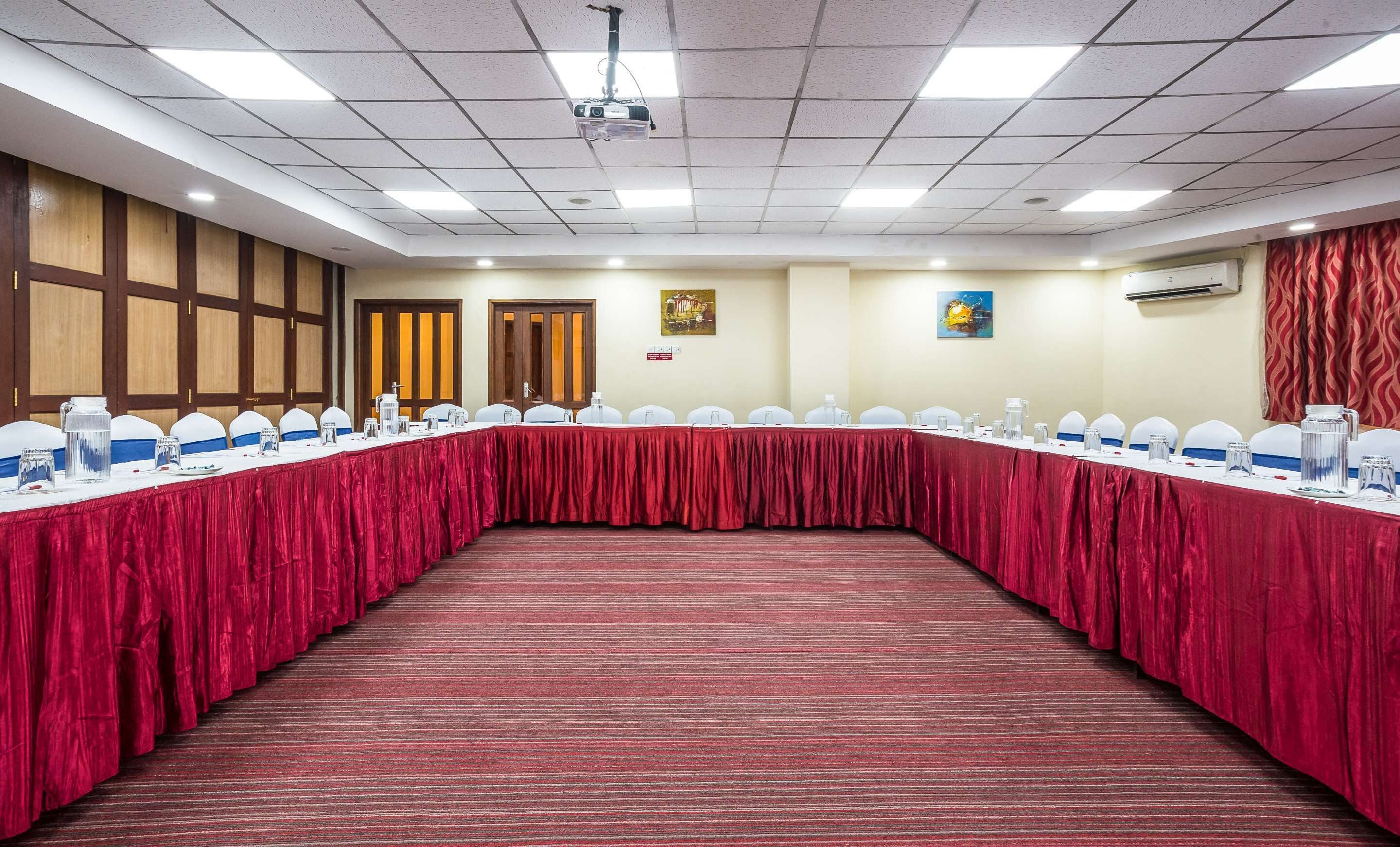 A conference room with a long table, chairs, and a projector.
