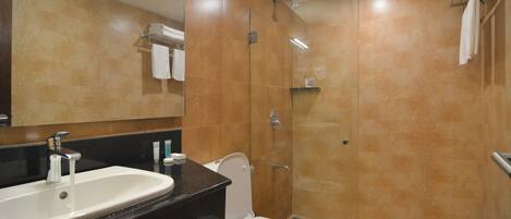 A bathroom with a sink, toilet, and glass shower enclosure.