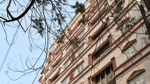 A multi-story building with balconies, a signboard, and parked motorcycles. - Princes Catba Hotel (Hai Phong)