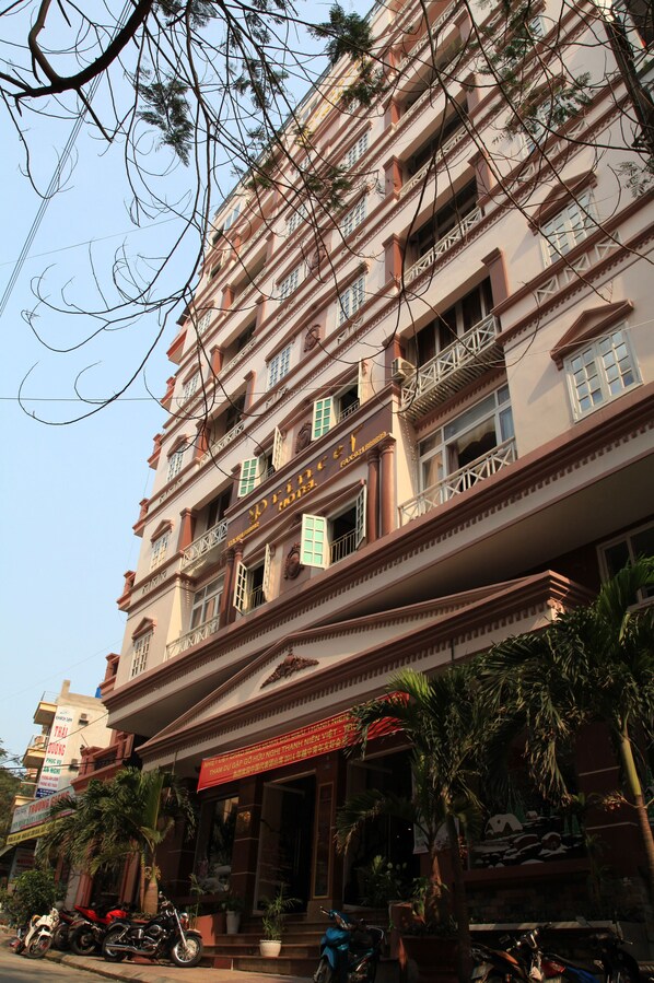 A multi-story building with balconies, a signboard, and parked motorcycles. - Princes Catba Hotel (Hai Phong)