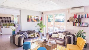 Een moderne woonkamer met leren banken, een salontafel en een boekenkast.