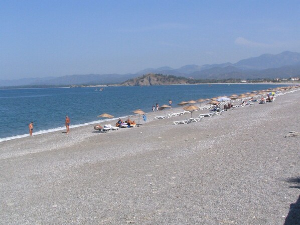 Platja a a prop, gandules de platja i para-sols per a la platja