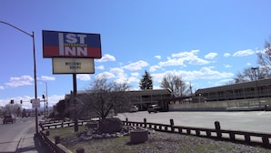 Un panneau indiquant l'autoroute de St. Inn, accueillant les motards, avec un ciel dégagé et une zone de stationnement au premier plan.