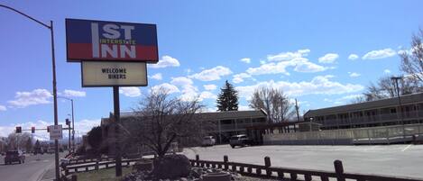A sign for the St. Inn Interstate, welcoming bikers, with a clear sky and a parking area in the foreground.