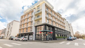 A multi-story hotel with a modern design, featuring balconies on each floor, a glass facade, and a parking lot in front. - Appart’City Confort Brest (Brest)