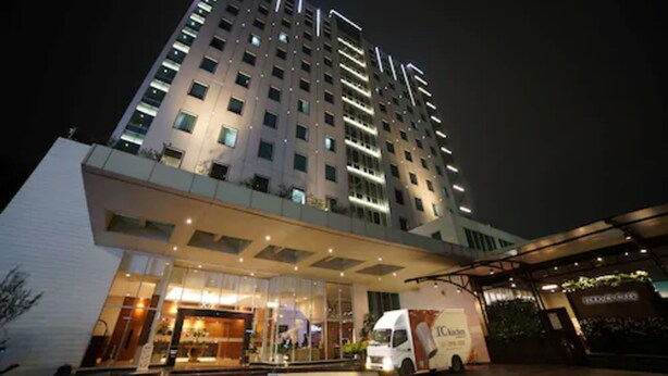 A multi-story hotel with a modern design, featuring a well-lit entrance and a visible truck outside. - PARK HOTEL Cawang - Jakarta (Jakarta)