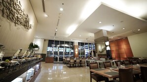 A modern hotel dining area with a buffet, multiple tables, and chairs. - PARK HOTEL Cawang - Jakarta (Jakarta)