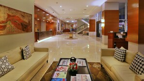 A hotel lobby with a reception desk, a staircase, and seating areas. - PARK HOTEL Cawang - Jakarta (Jakarta)