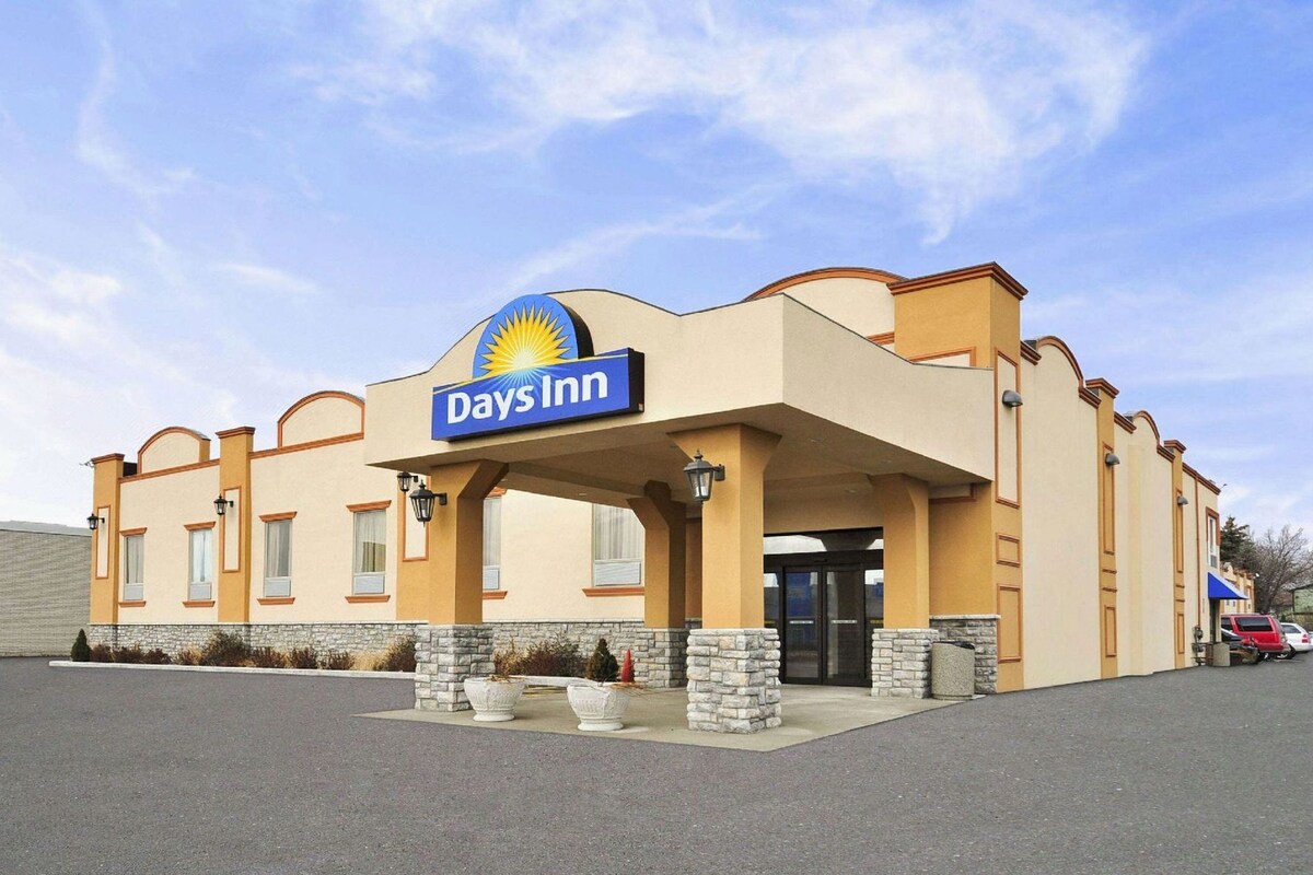 Un hôtel Days Inn, reconnaissable à son enseigne bien visible, son entrée abritée et son parking.